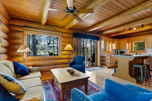 662 S Foys Lake Dr, Kalispell, MT 59901 - living room featuring a wood ceiling with exposed beams, log walls, light wood finished floors, and ceiling fan