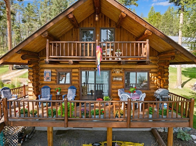 662 S Foys Lake Dr, Kalispell, MT 59901 - rear view of house featuring log exterior, a balcony, and a deck
