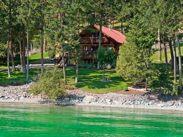 662 S Foys Lake Dr, Kalispell, MT 59901 - rear view of house with a lawn, a deck with water view, and log siding