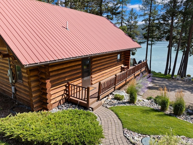 662 S Foys Lake Dr, Kalispell, MT 59901 - rear view of house featuring log exterior, a water view, and a metal roof