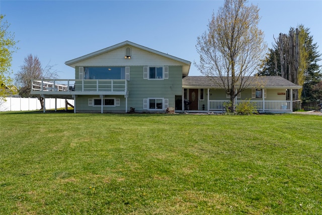 rear view of property featuring a yard, a porch, and fence