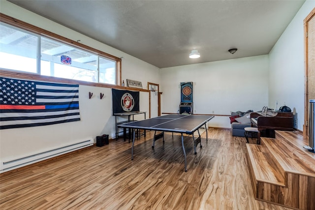 playroom featuring a baseboard heating unit and wood finished floors