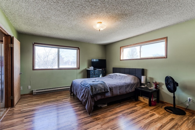 bedroom featuring a baseboard radiator, a textured ceiling, and wood finished floors