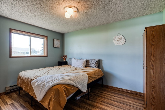 bedroom with a textured ceiling, baseboards, wood finished floors, and baseboard heating
