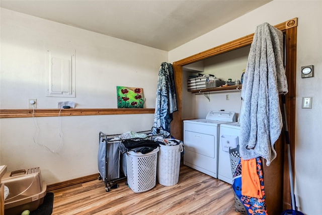 clothes washing area with baseboards, laundry area, separate washer and dryer, and light wood-type flooring