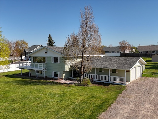 back of house with an attached garage, a porch, driveway, and a lawn
