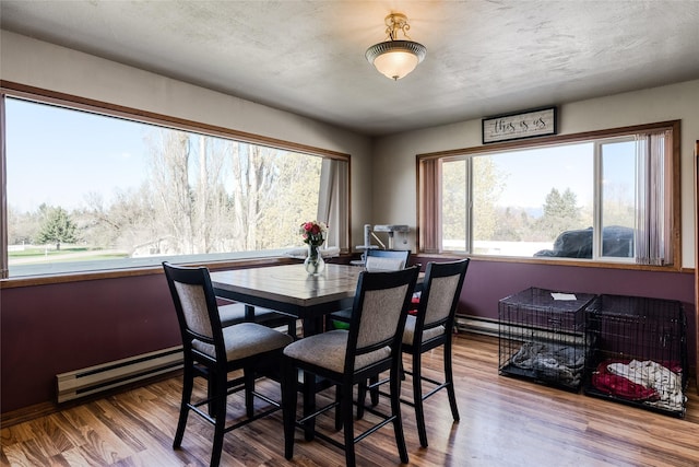 dining room with baseboard heating and wood finished floors