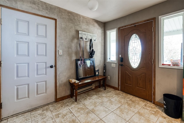 foyer featuring light tile patterned floors, baseboards, and a baseboard radiator