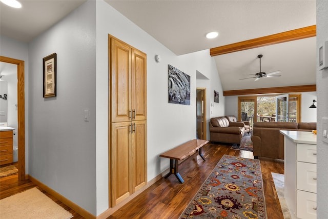 corridor with baseboards, lofted ceiling with beams, and dark wood-style floors