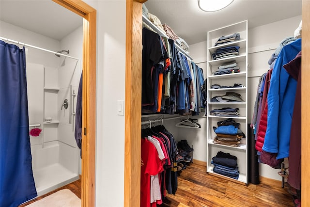 walk in closet with wood finished floors