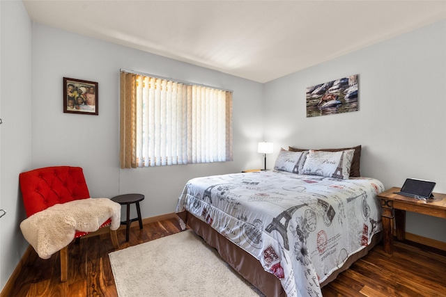 bedroom with baseboards and wood finished floors