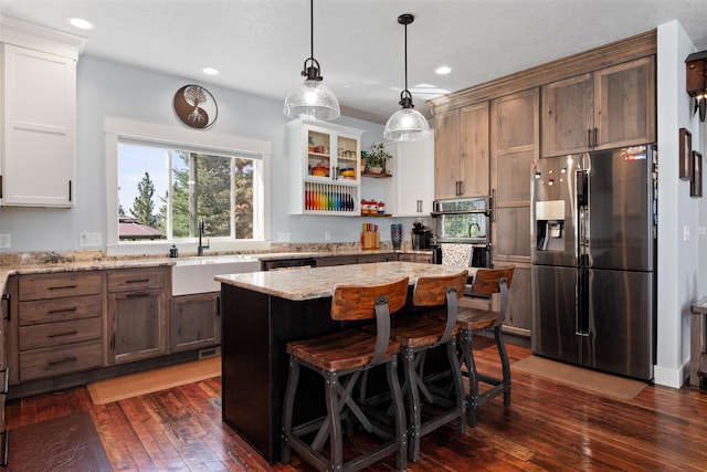 kitchen with stainless steel fridge with ice dispenser, a sink, dark wood finished floors, light stone countertops, and open shelves