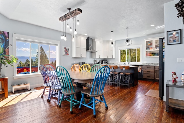 dining room with dark wood-type flooring, recessed lighting, and a textured ceiling