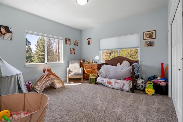 carpeted bedroom with multiple windows and a closet