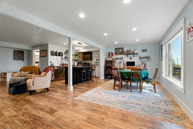 dining room featuring bar area, light wood-type flooring, recessed lighting, and baseboards