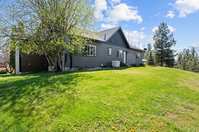 rear view of house with a yard and board and batten siding