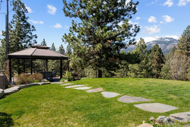 view of green lawn featuring a gazebo and a mountain view