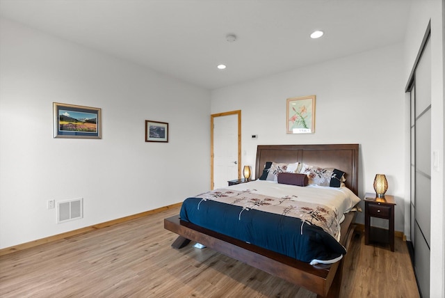 bedroom with recessed lighting, wood finished floors, visible vents, and access to exterior