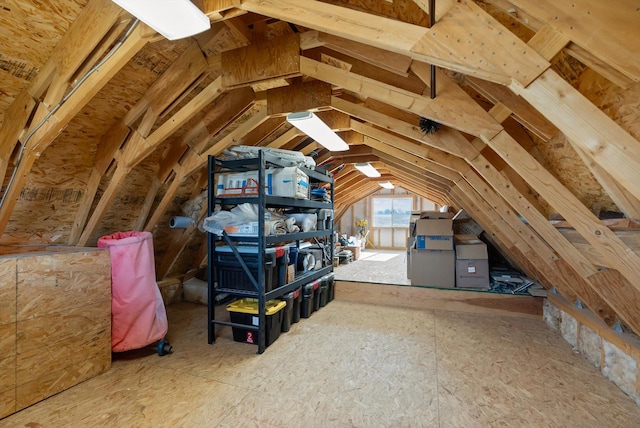 garage with a wood stove, freestanding refrigerator, baseboards, and recessed lighting
