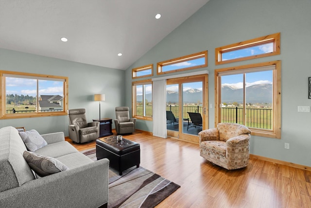 living room with recessed lighting, light wood-type flooring, and high vaulted ceiling
