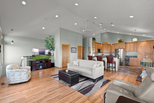 living room featuring a mountain view, high vaulted ceiling, light wood-type flooring, recessed lighting, and baseboards