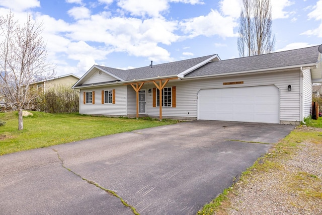 ranch-style house featuring driveway, a shingled roof, a front yard, and an attached garage