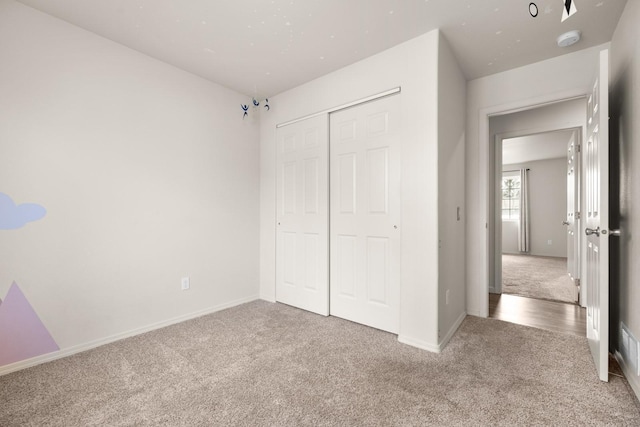 unfurnished bedroom featuring baseboards, a closet, and carpet