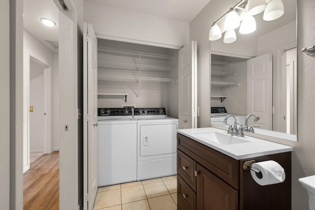 laundry room featuring a sink, laundry area, light tile patterned floors, and washer and dryer