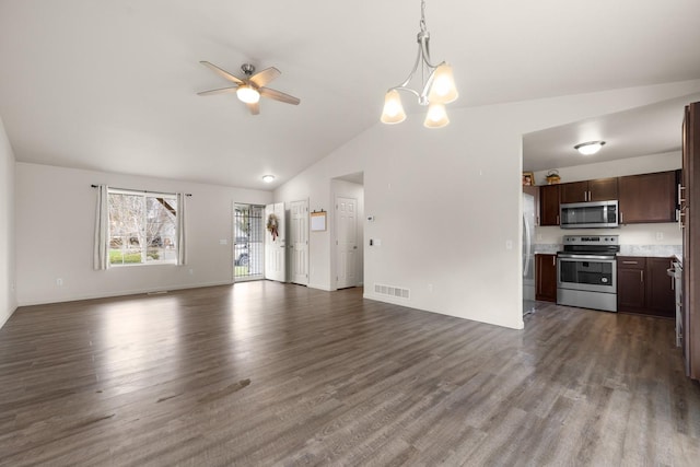 unfurnished living room with lofted ceiling, baseboards, visible vents, ceiling fan with notable chandelier, and dark wood-type flooring