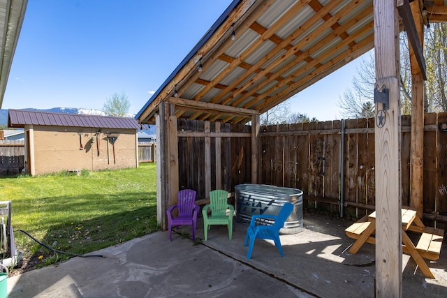 view of patio featuring an outbuilding and fence
