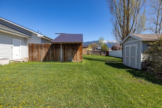 view of yard featuring a fenced backyard, an outdoor structure, and a shed