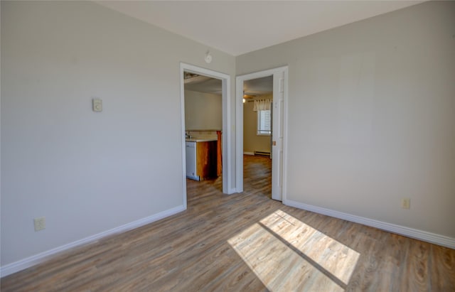 unfurnished room featuring baseboards and wood finished floors