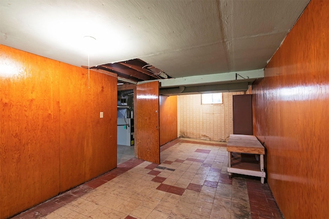 below grade area with tile patterned floors and wooden walls
