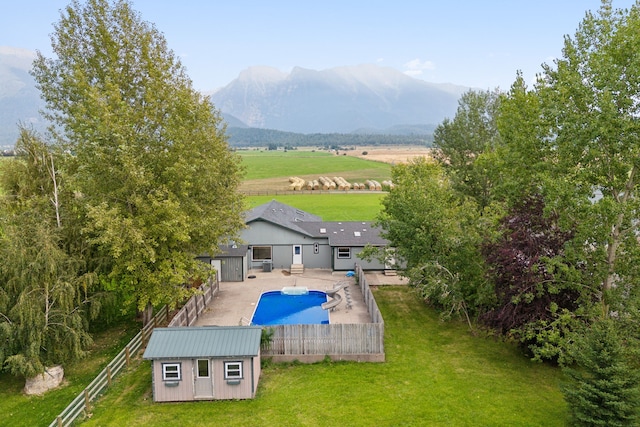 61574 Hillside Rd, Saint Ignatius, MT 59865 - view of swimming pool with a lawn, an outdoor structure, a fenced backyard, a shed, and a fenced in pool
