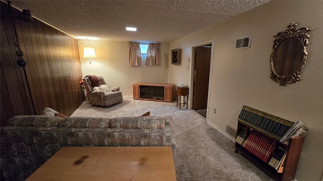 living area with a textured ceiling, carpet flooring, and visible vents