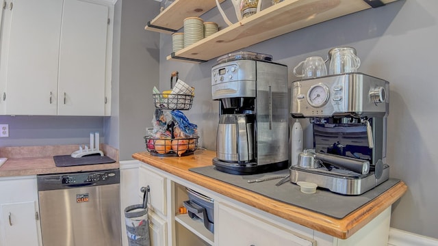 kitchen featuring stainless steel dishwasher, white cabinetry, and wooden counters
