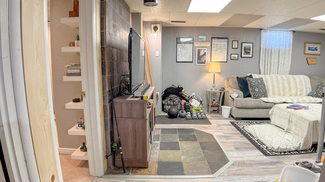 living room featuring baseboards, visible vents, and wood finished floors