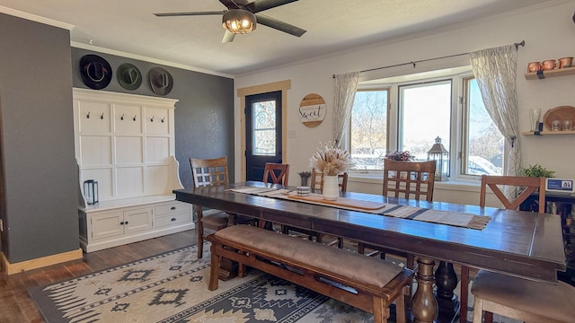 dining area with crown molding, dark wood-style flooring, baseboards, and a ceiling fan