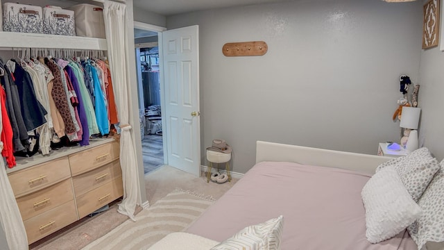 bedroom with baseboards and light carpet