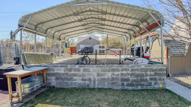 view of parking with fence, a storage shed, and a carport