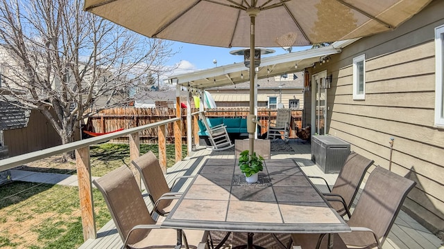 wooden terrace with fence private yard, outdoor dining space, and an outdoor living space