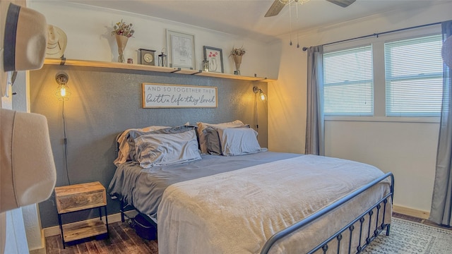 bedroom featuring ceiling fan, ornamental molding, baseboards, and wood finished floors
