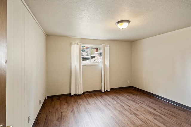 172 Holt Dr Unit A, B & C, Bigfork, MT 59911 - unfurnished room featuring a textured ceiling, wood finished floors, and baseboards