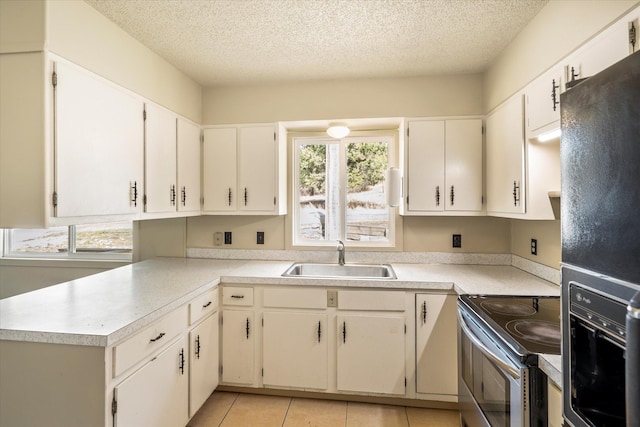 172 Holt Dr Unit A, B & C, Bigfork, MT 59911 - kitchen with black refrigerator with ice dispenser, a textured ceiling, a sink, stainless steel range with electric stovetop, and light countertops