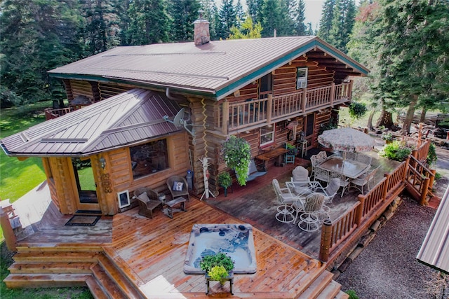 4212 Foothill Rd, Kalispell, MT 59901 - rear view of property featuring outdoor dining area, log siding, a metal roof, and a chimney