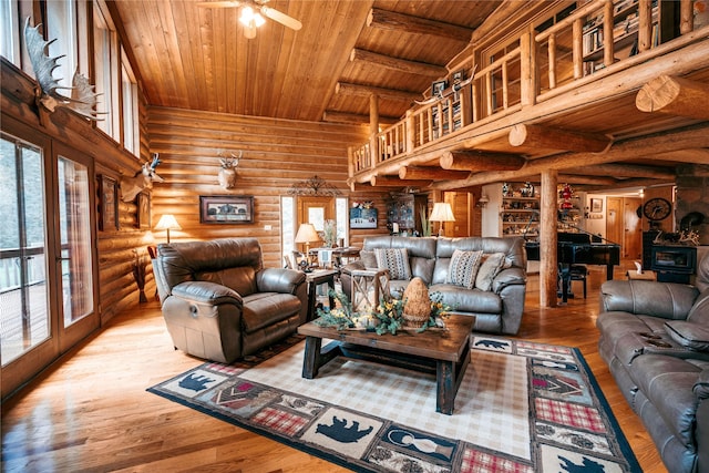 living room featuring wood finished floors, beam ceiling, log walls, a ceiling fan, and wood ceiling