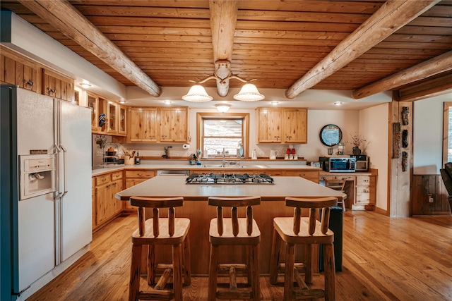 4212 Foothill Rd, Kalispell, MT 59901 - kitchen with white fridge with ice dispenser, a wooden ceiling with exposed beams, stainless steel gas cooktop, light countertops, and light wood-style floors