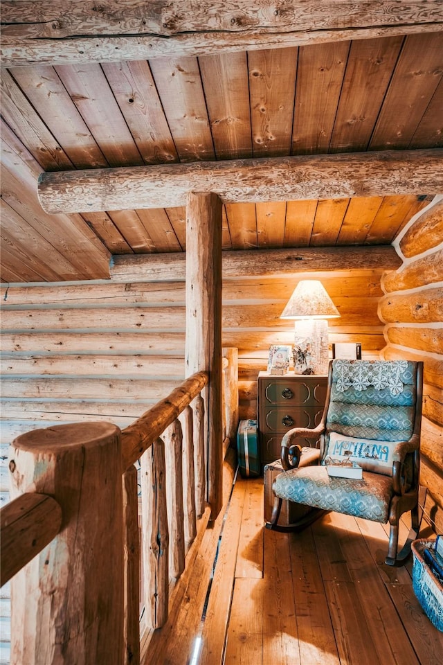 living area with wood ceiling, hardwood / wood-style floors, and rustic walls