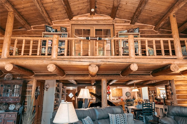 interior space with wood ceiling, rustic walls, and lofted ceiling with beams