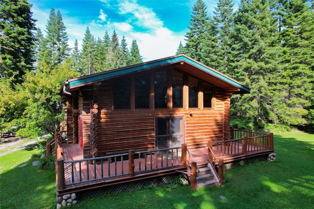 exterior space featuring a lawn, a wooden deck, and log siding